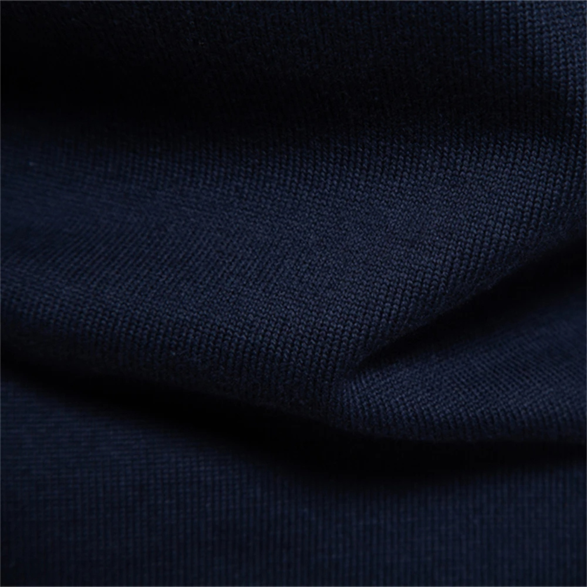 Men's dark knit polo sweater fabric close-up showing ribbed hem fold