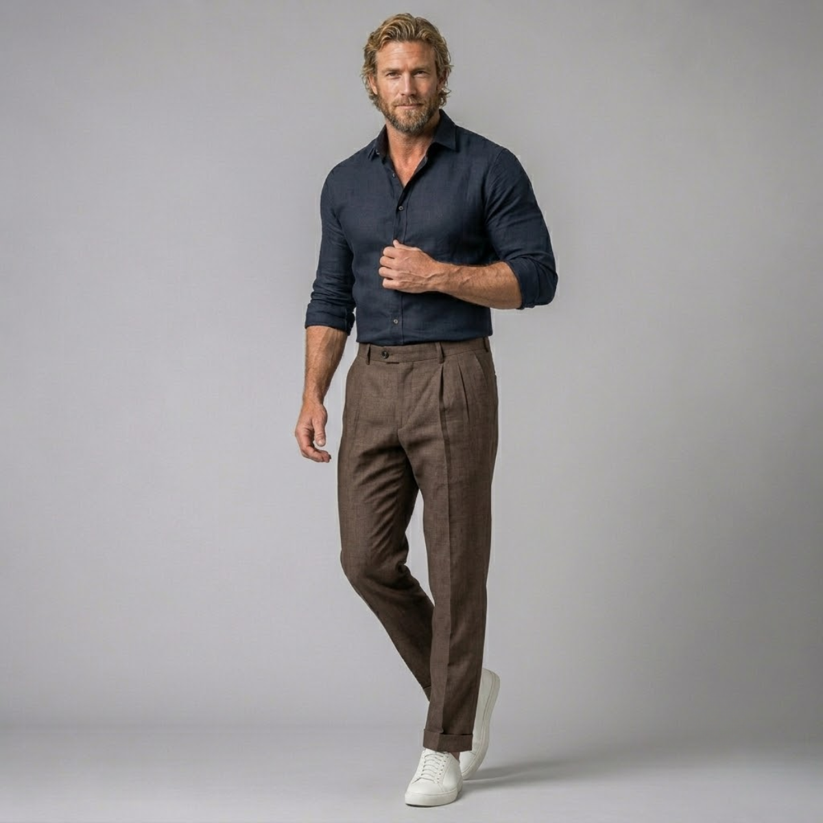 Men's brown slim-fit lightweight linen dress pants on model, pleated front, cuffed hem