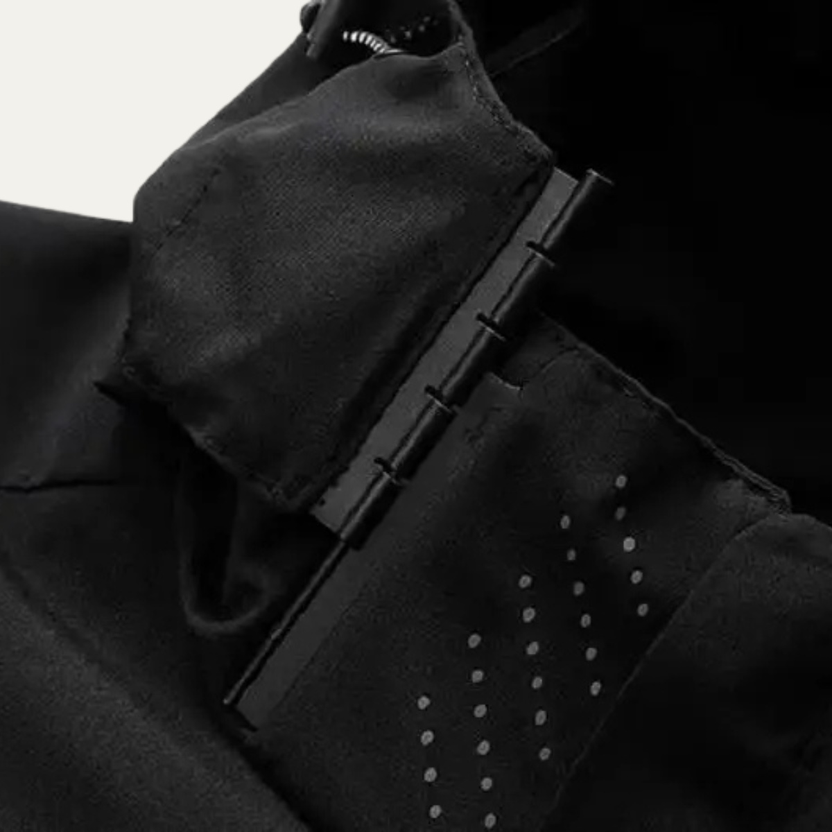 Black rain jacket sleeve and pocket with snap/adjuster tabs and dotted mesh lining