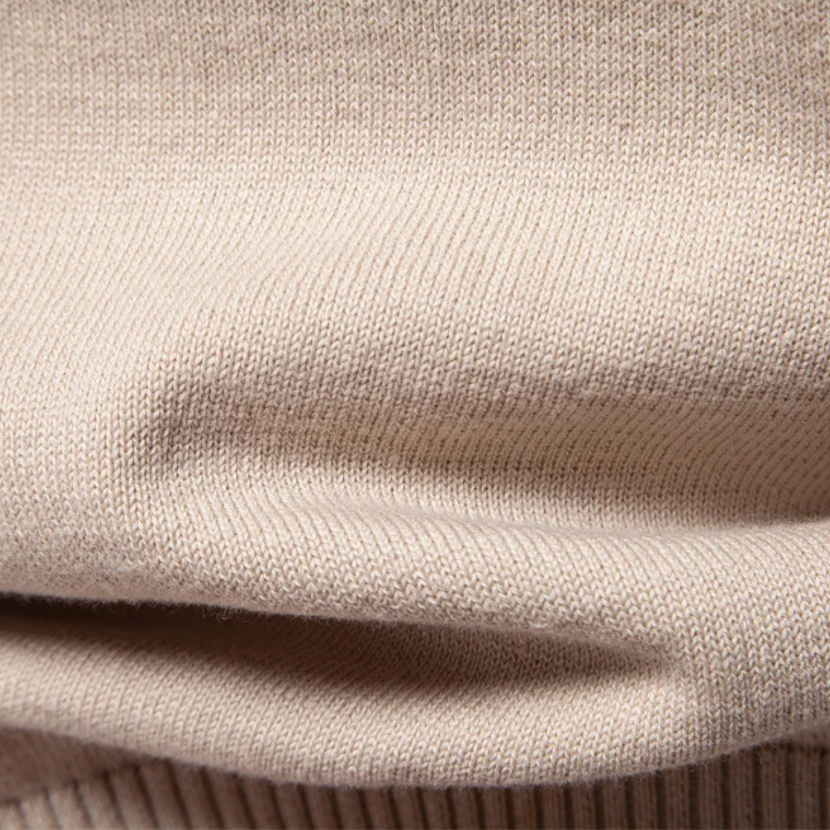 Beige knit sweater sleeve hem with ribbed cuff and folded knit texture