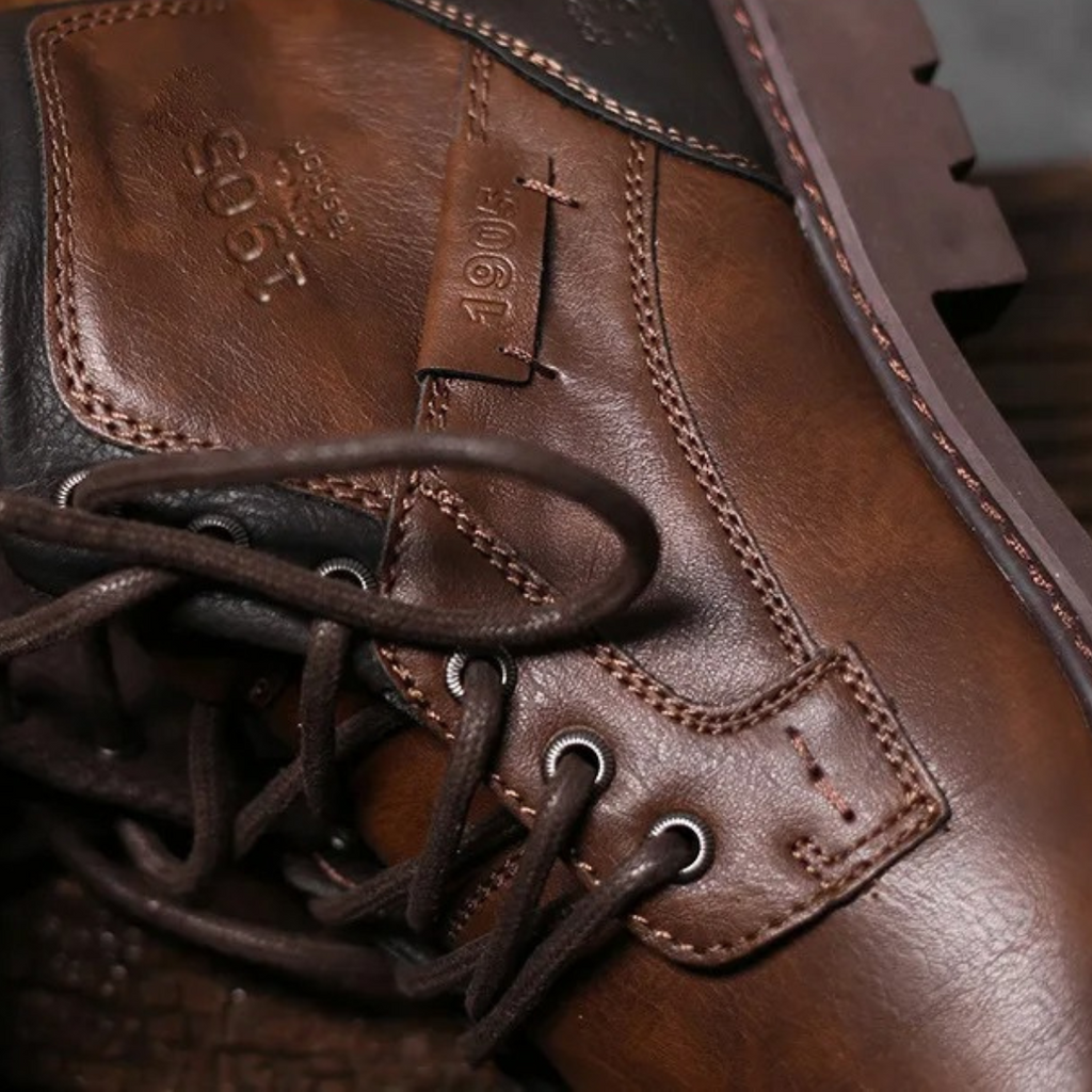 Brown leather combat boot upper with lace eyelets and stitched toe panel