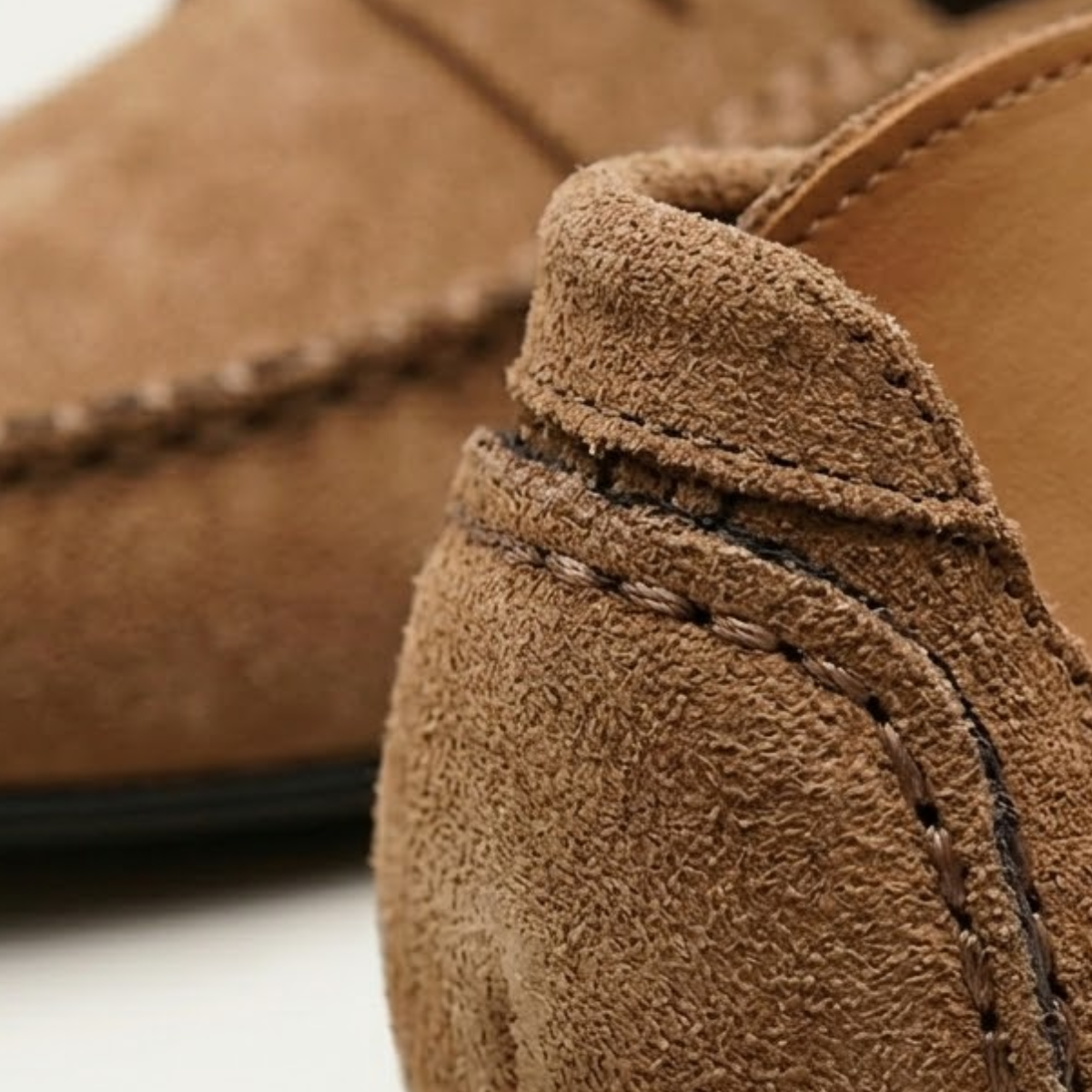 Tan suede moccasin loafer slip-on with stitched seam and braided moc toe