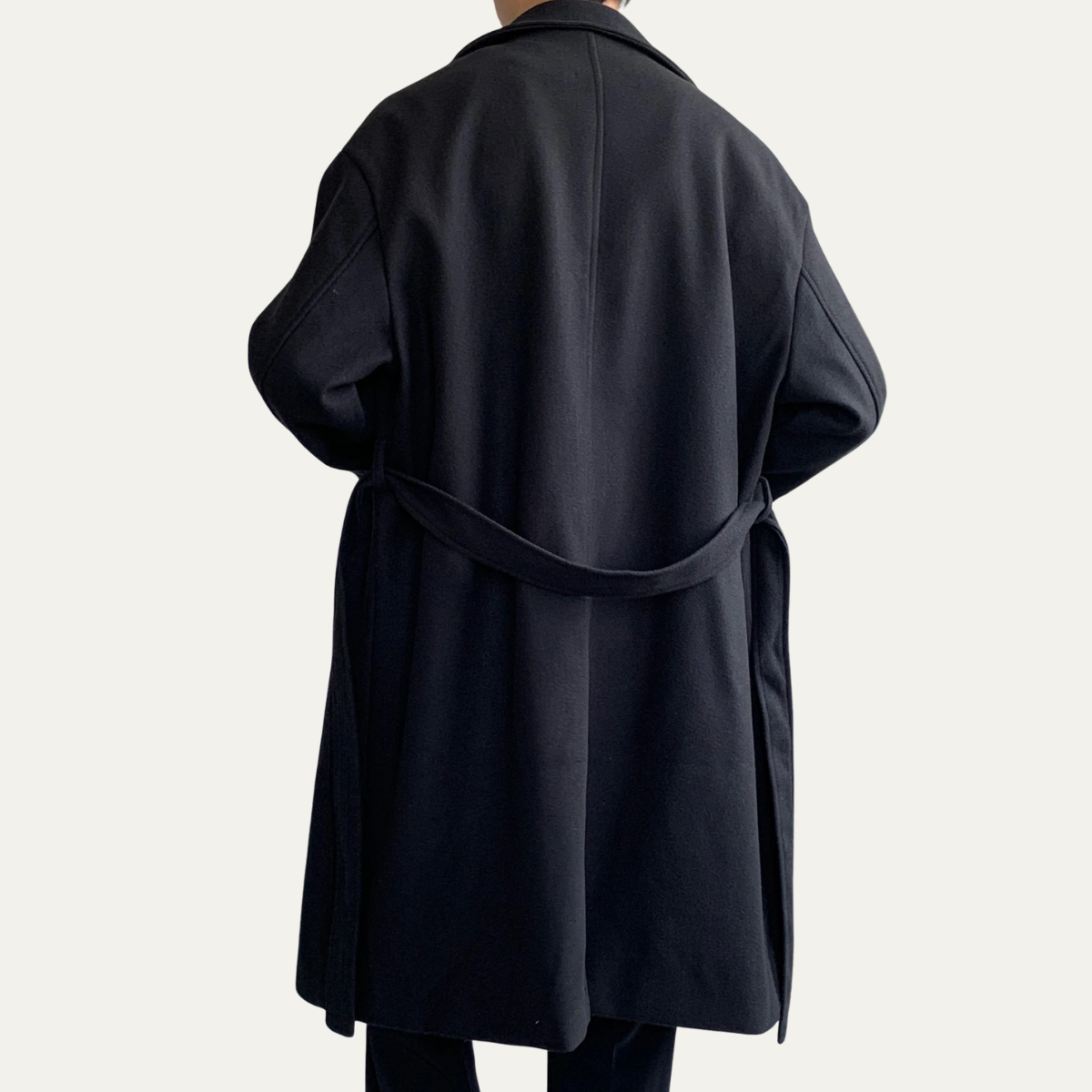Black wool overcoat back view with waist tie belt and relaxed fit