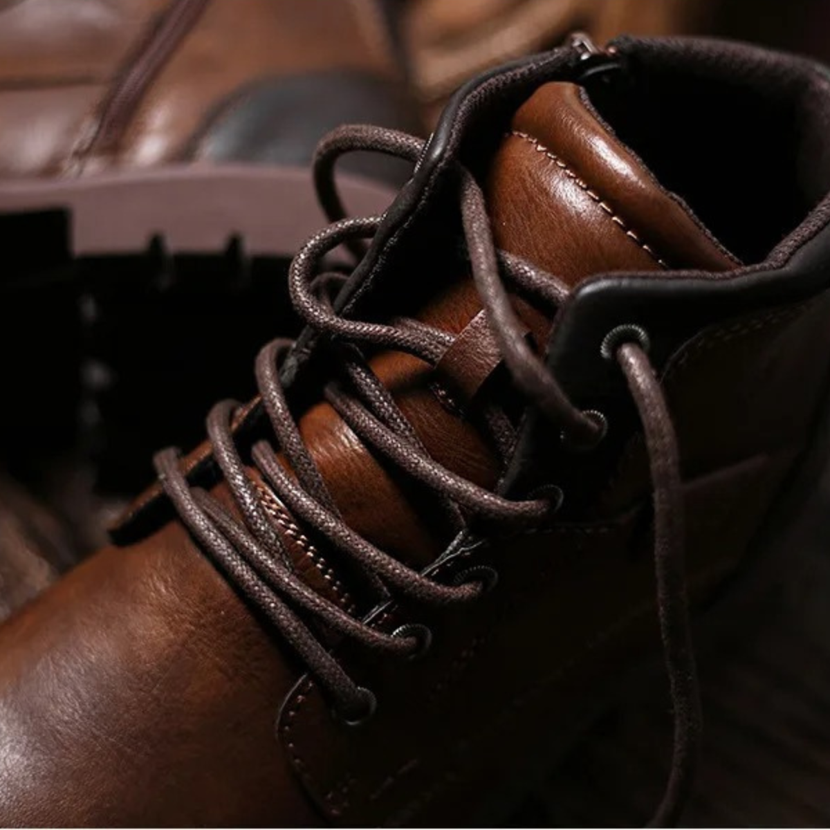 Brown leather lace-up combat boots with rugged outsole and side stitching