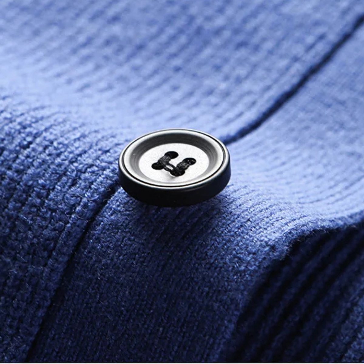 Blue knit sweater vest button placket with round black buttons