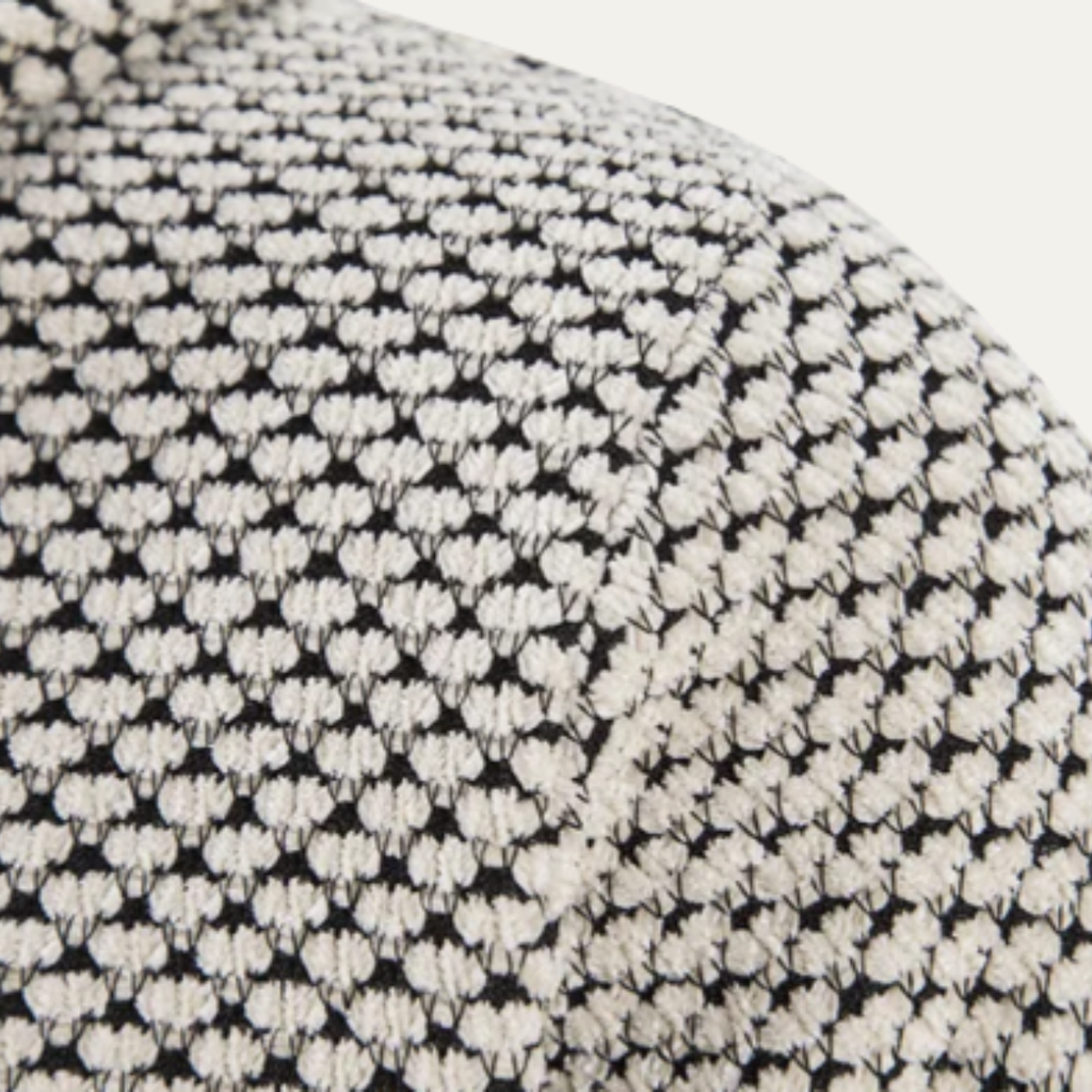 Close-up of black-and-cream textured knit fabric pattern on hoodie