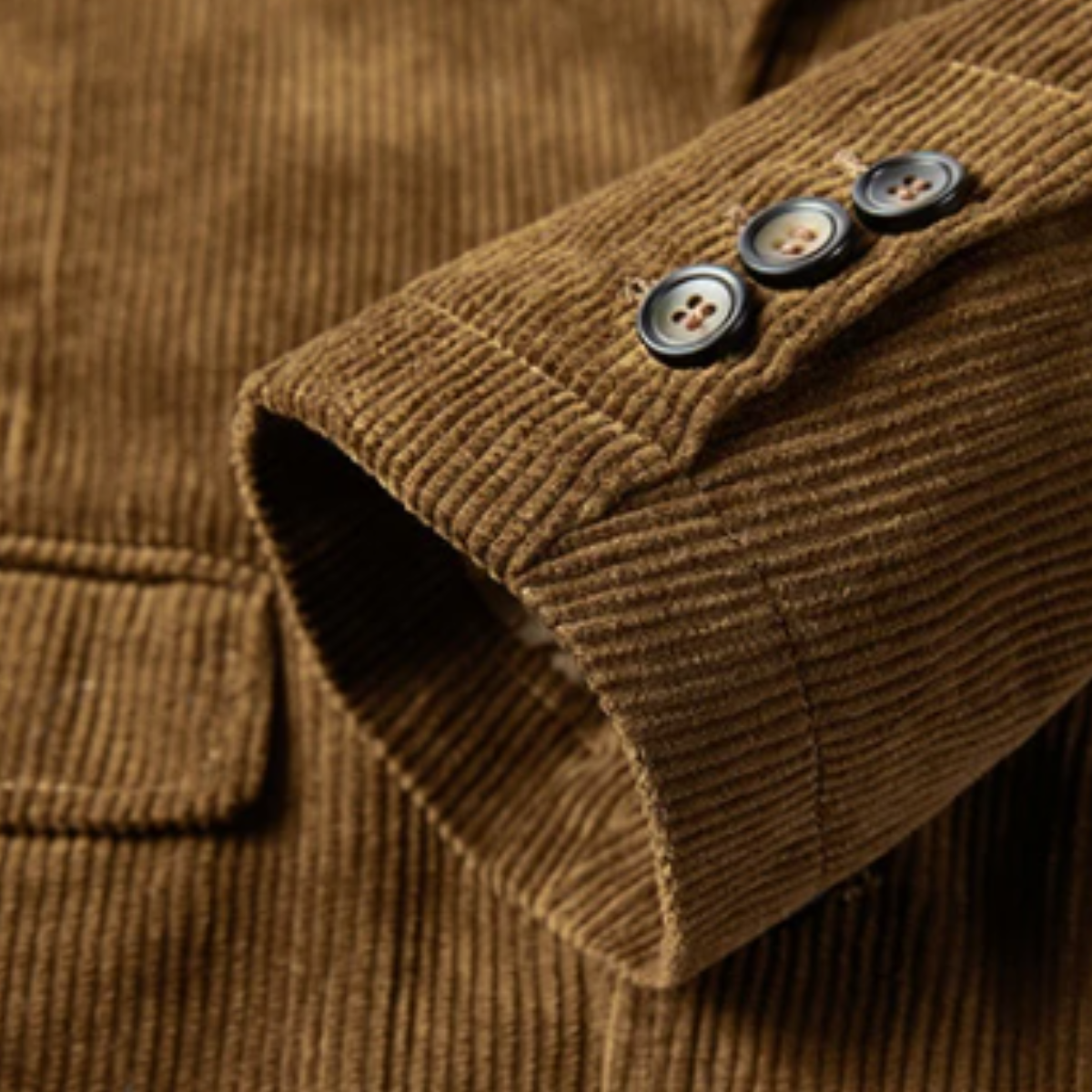 Close-up of brown corduroy sleeve cuff with two buttons.