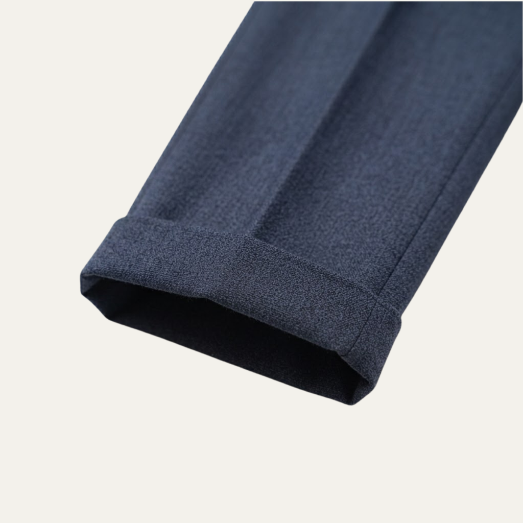 Men's high-waisted pleated dress pants in dark blue, textured fabric and folded cuff