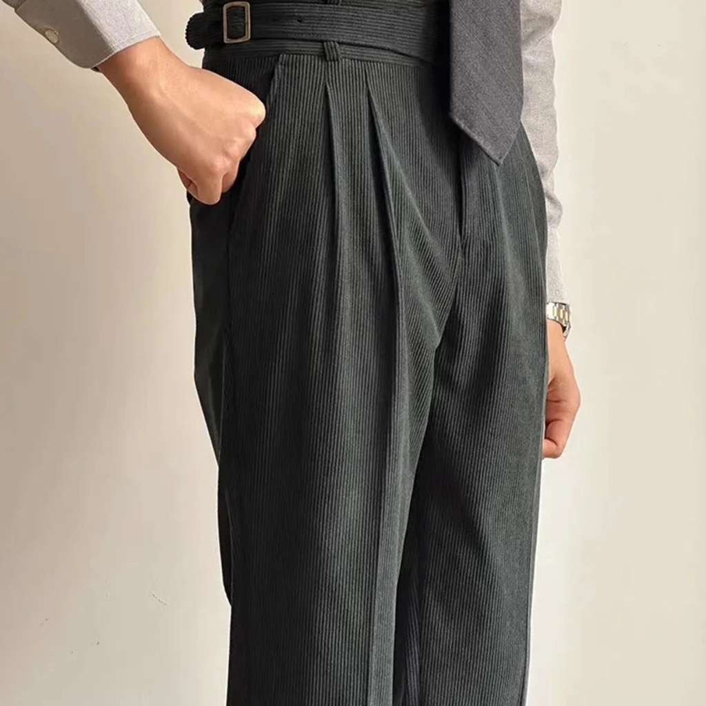 Dark green corduroy high-waisted pleated pants with side adjuster tabs at waistband