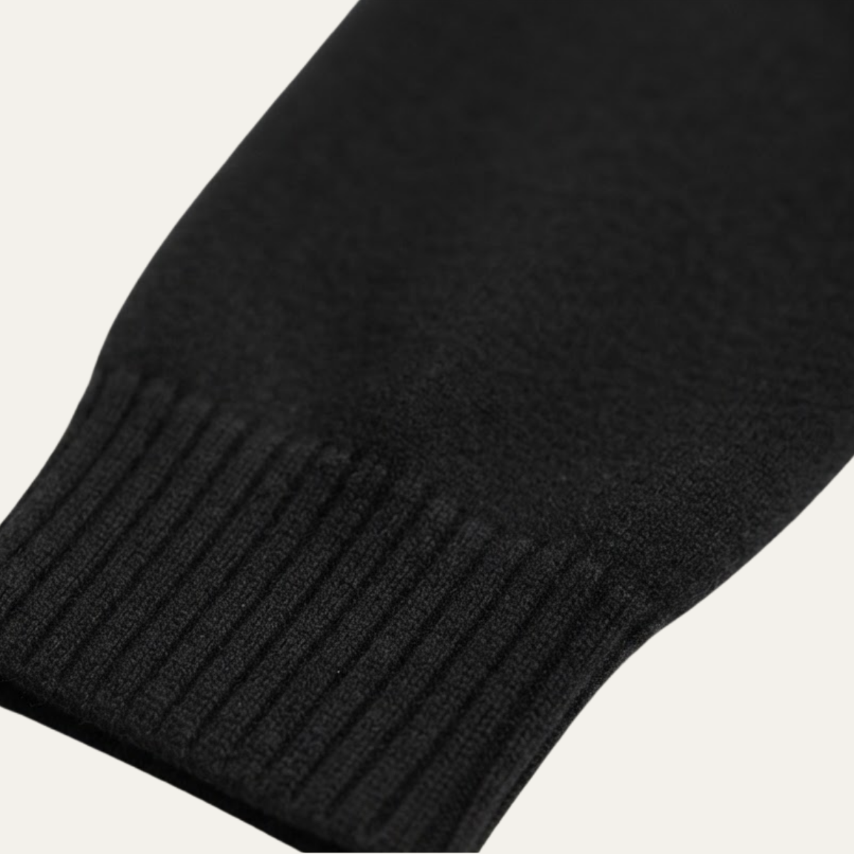 Black sweater sleeve cuff with ribbed knit and stitched seam detail