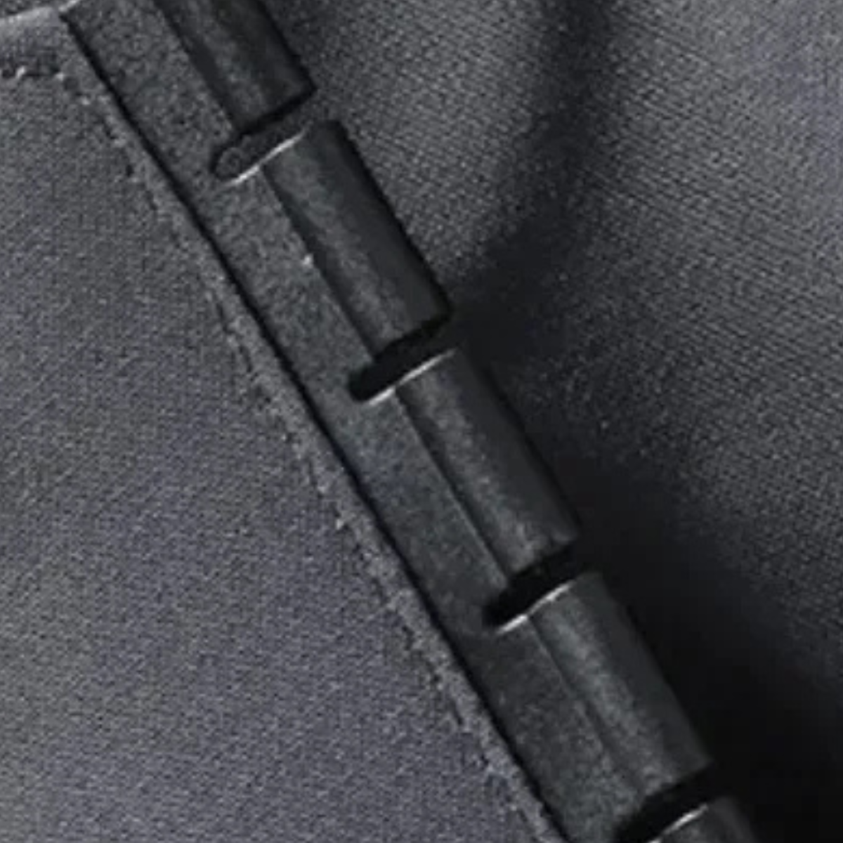Black rain jacket zipper seam and pull detail on textured fabric