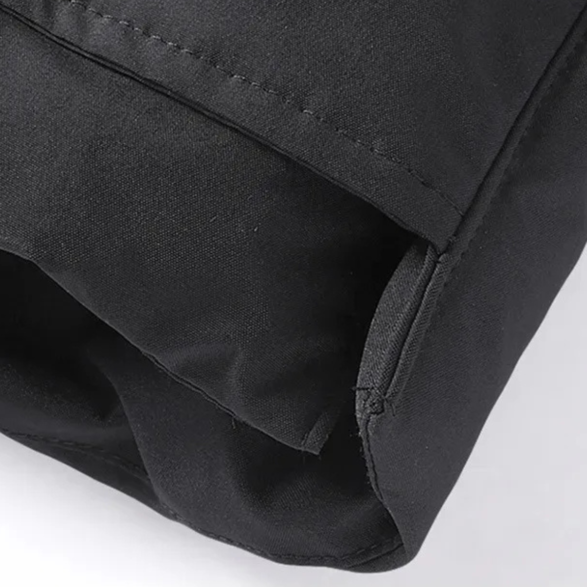 Black puffer jacket close-up of lower hem seam and side pocket edge