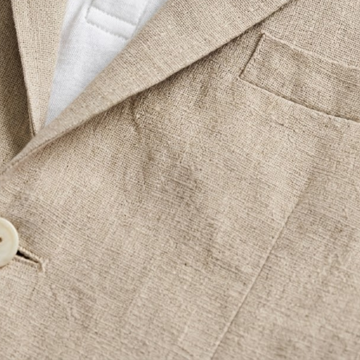 Close-up of khaki blazer sleeve and chest area with fabric texture and stitching