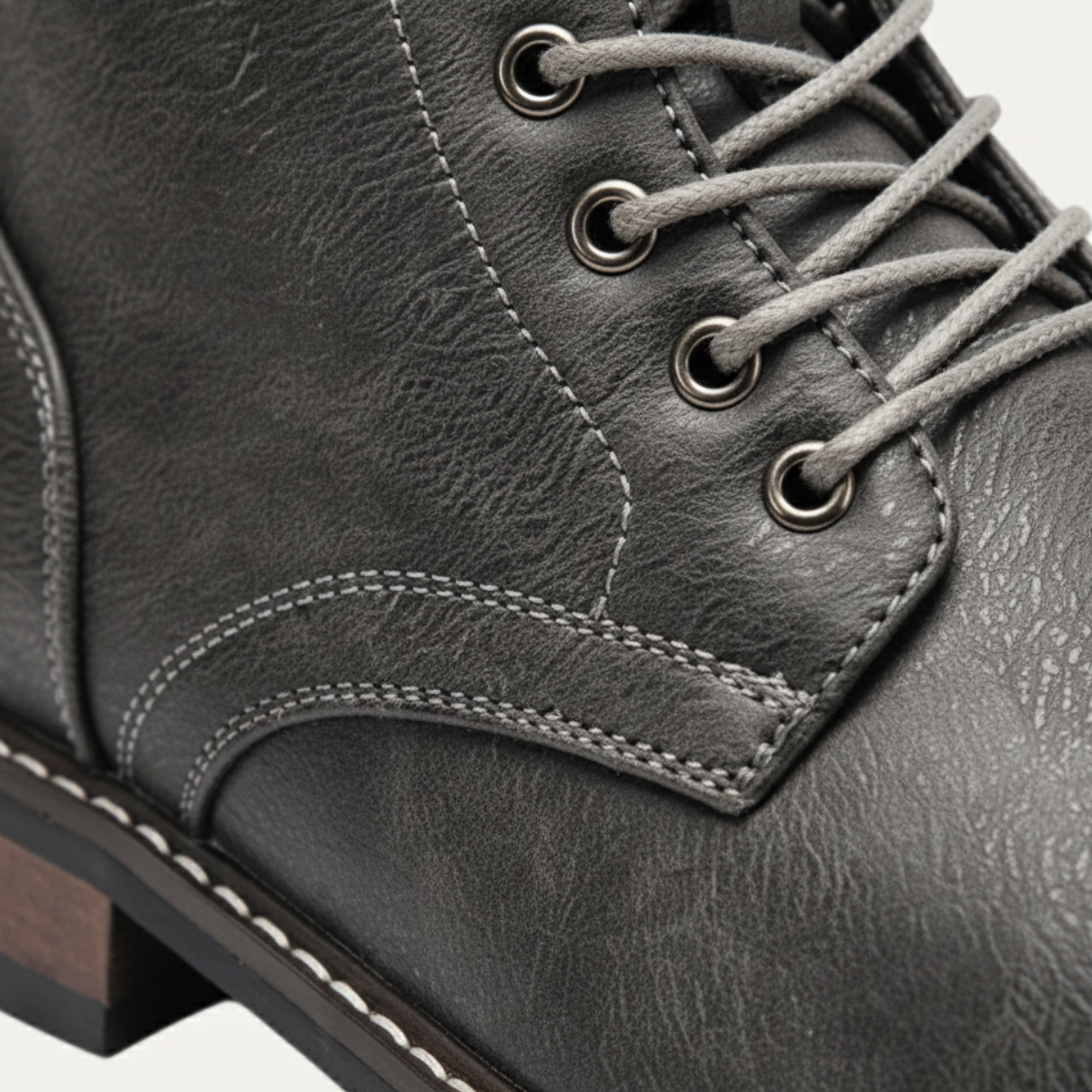 Men's dark gray lace-up ankle boot close-up of lace eyelets and cushioned collar