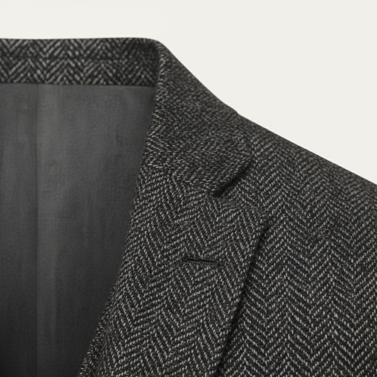 Dark gray herringbone tweed suit jacket shoulder and lapel close-up