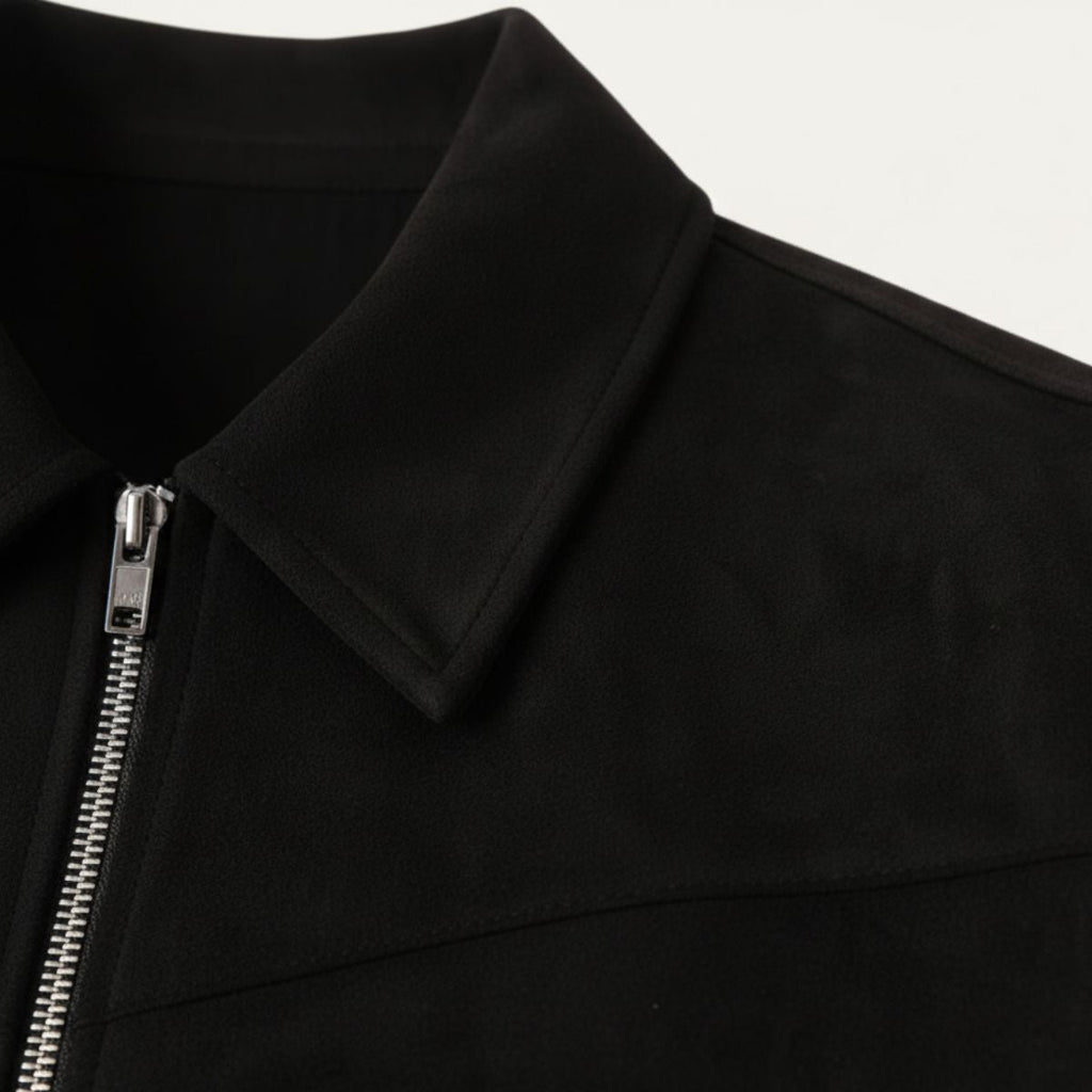 Black suede jacket close-up: point collar and silver zipper with pull tab