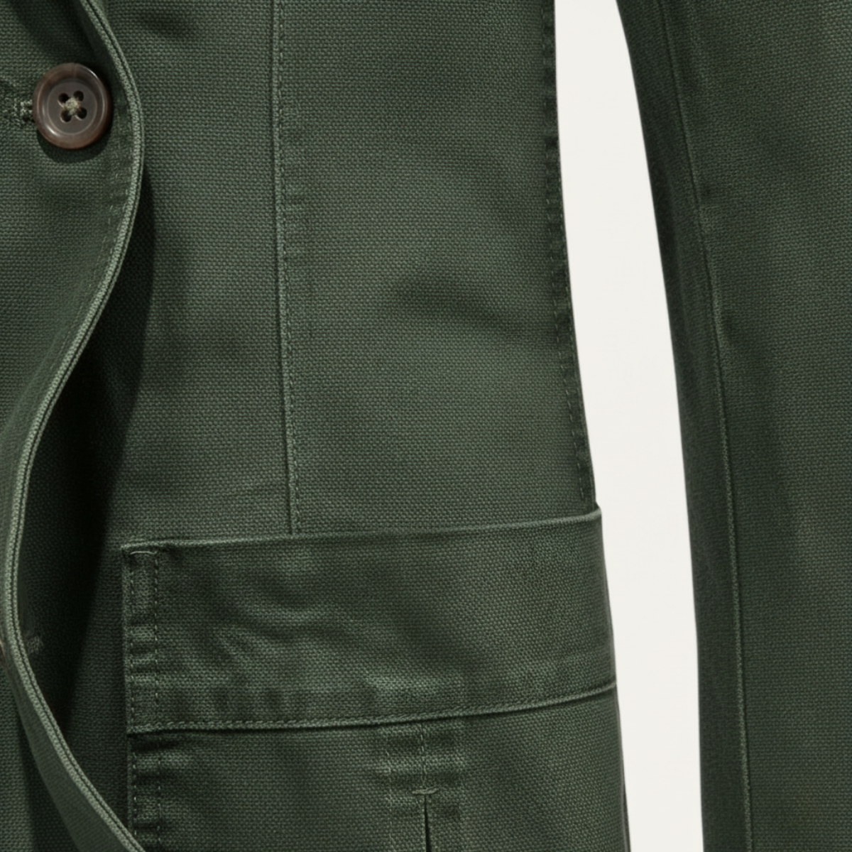 Army green lightweight jacket close-up of sleeve cuff and front pocket stitching