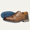 Brown lace-up leather oxford shoe outsole view with textured blue tread