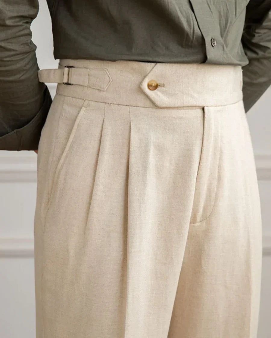 Beige pleated linen pants with button waist, belt loops, and front pleats