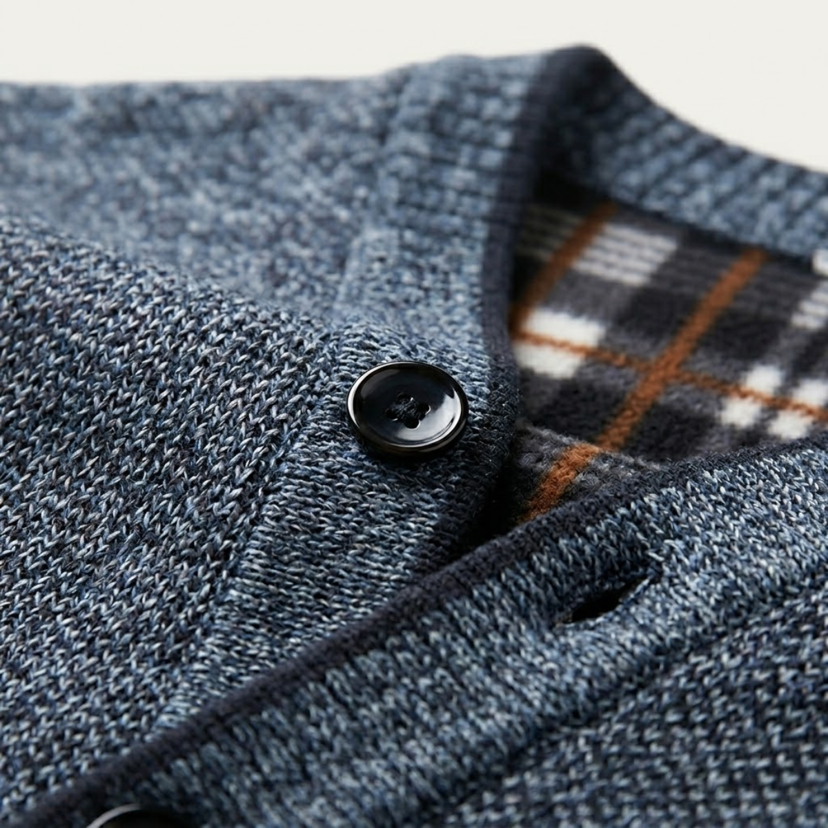 Blue heather knit cardigan close-up with black buttons and plaid inner collar