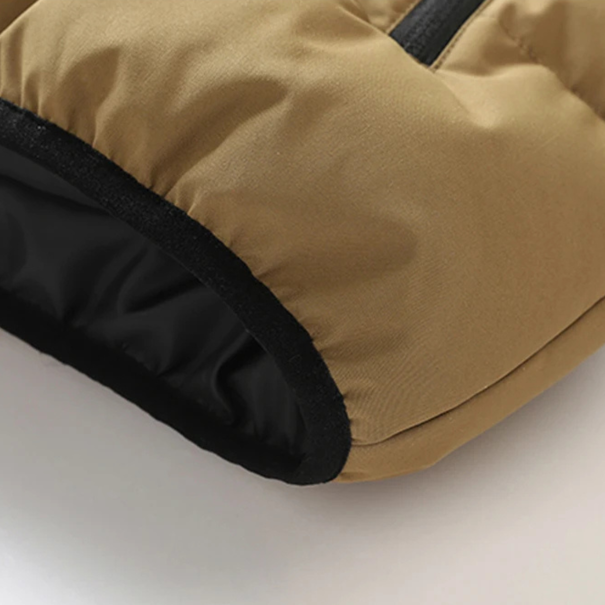 Khaki puffer vest hem with black inner lining and elastic edge