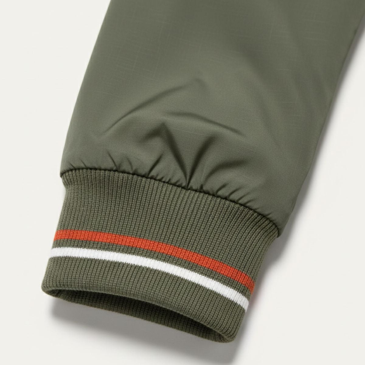 Sage green lightweight bomber jacket ribbed hem with orange, white, and striped band