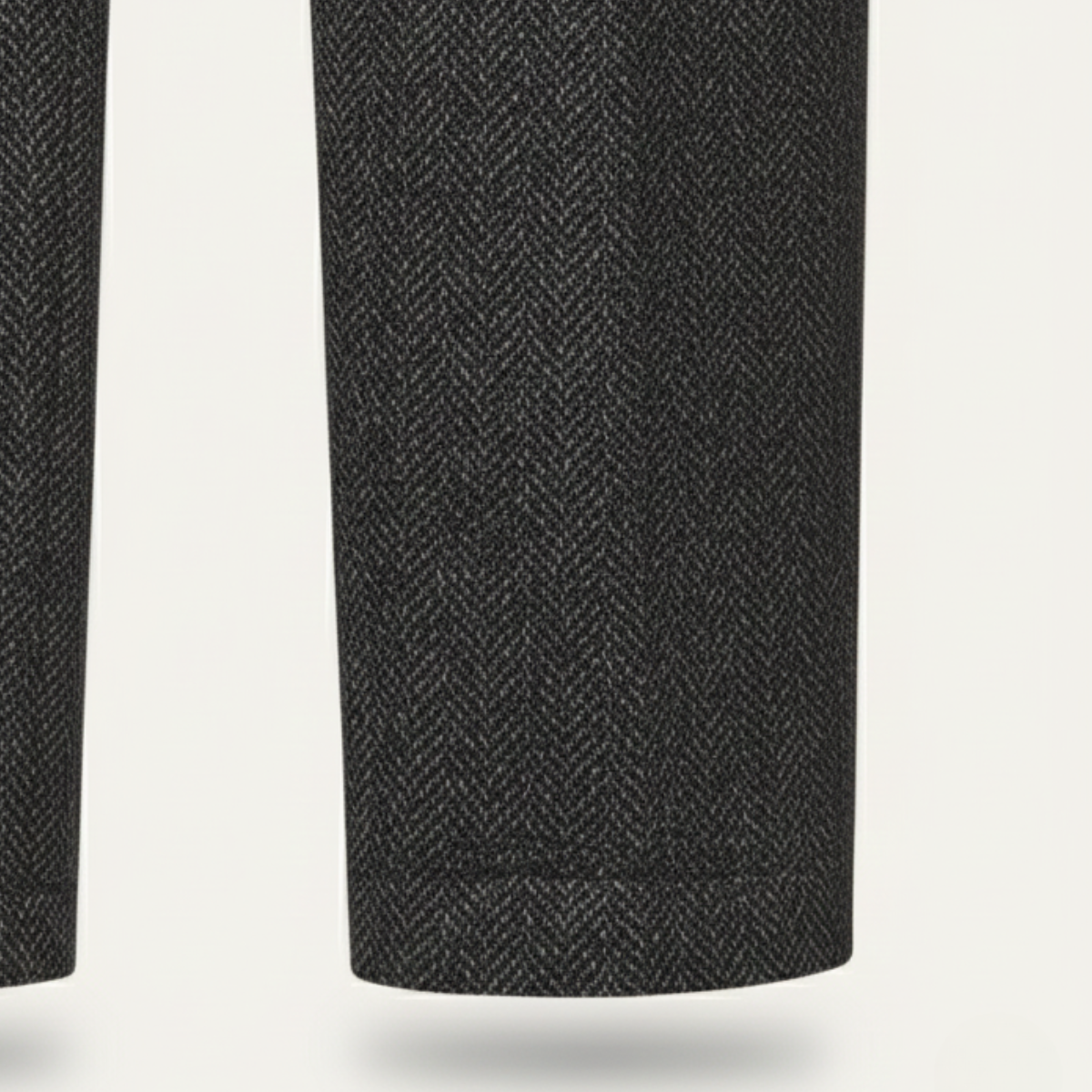 Dark gray herringbone tweed suit pants leg close-up