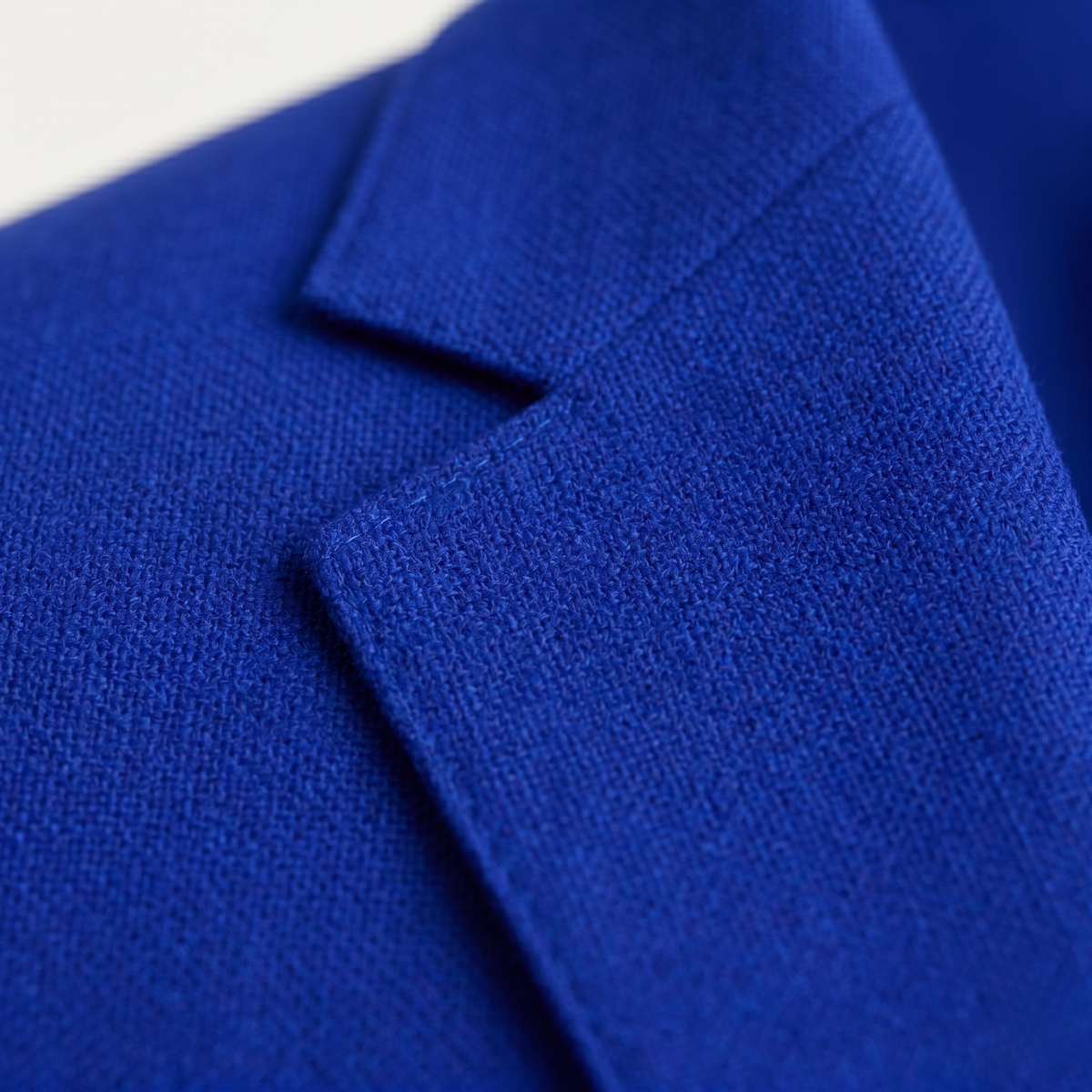 Blue suit jacket fabric texture close-up with folded lapel