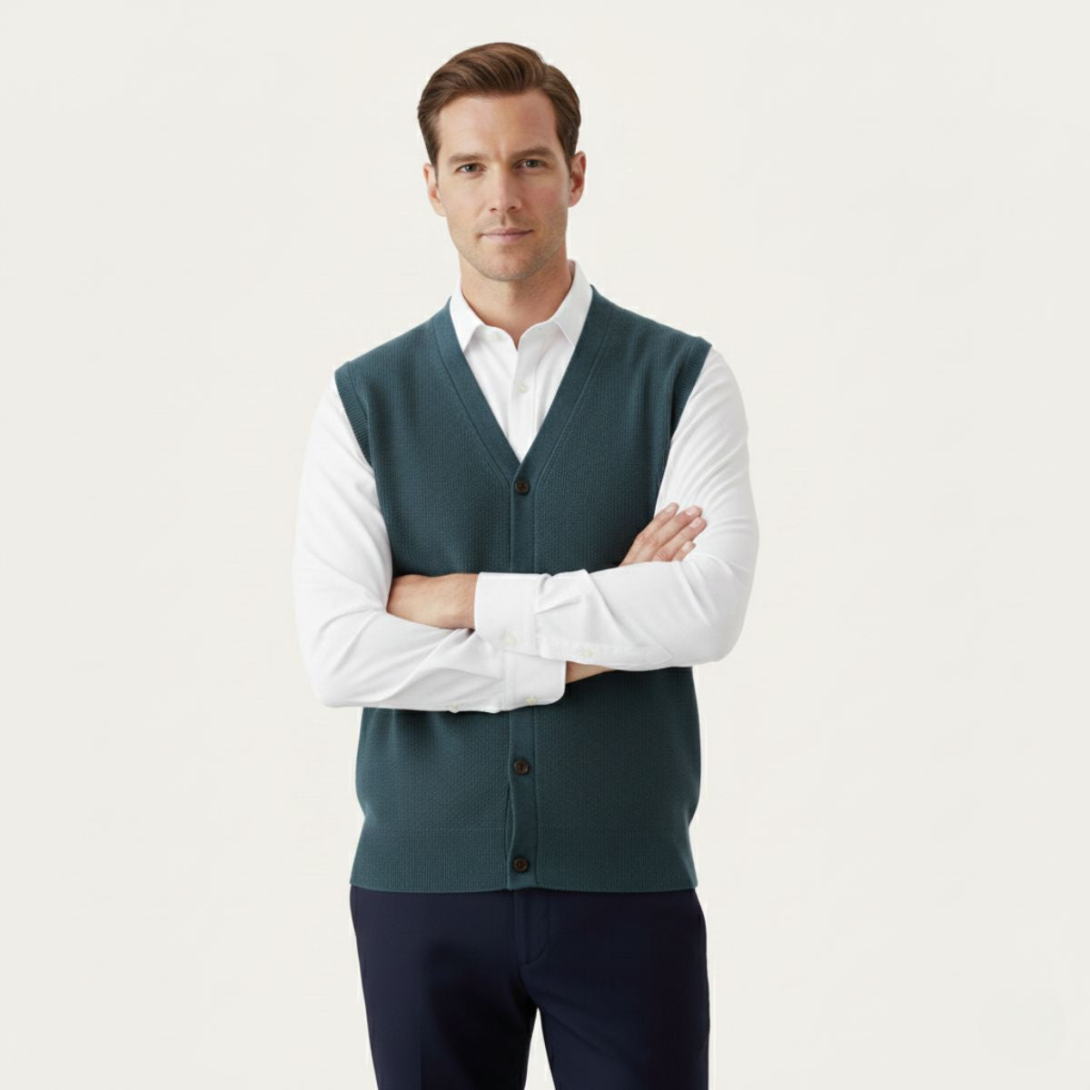Men’s deep green knit waistcoat sweater vest worn over a white button-up shirt.