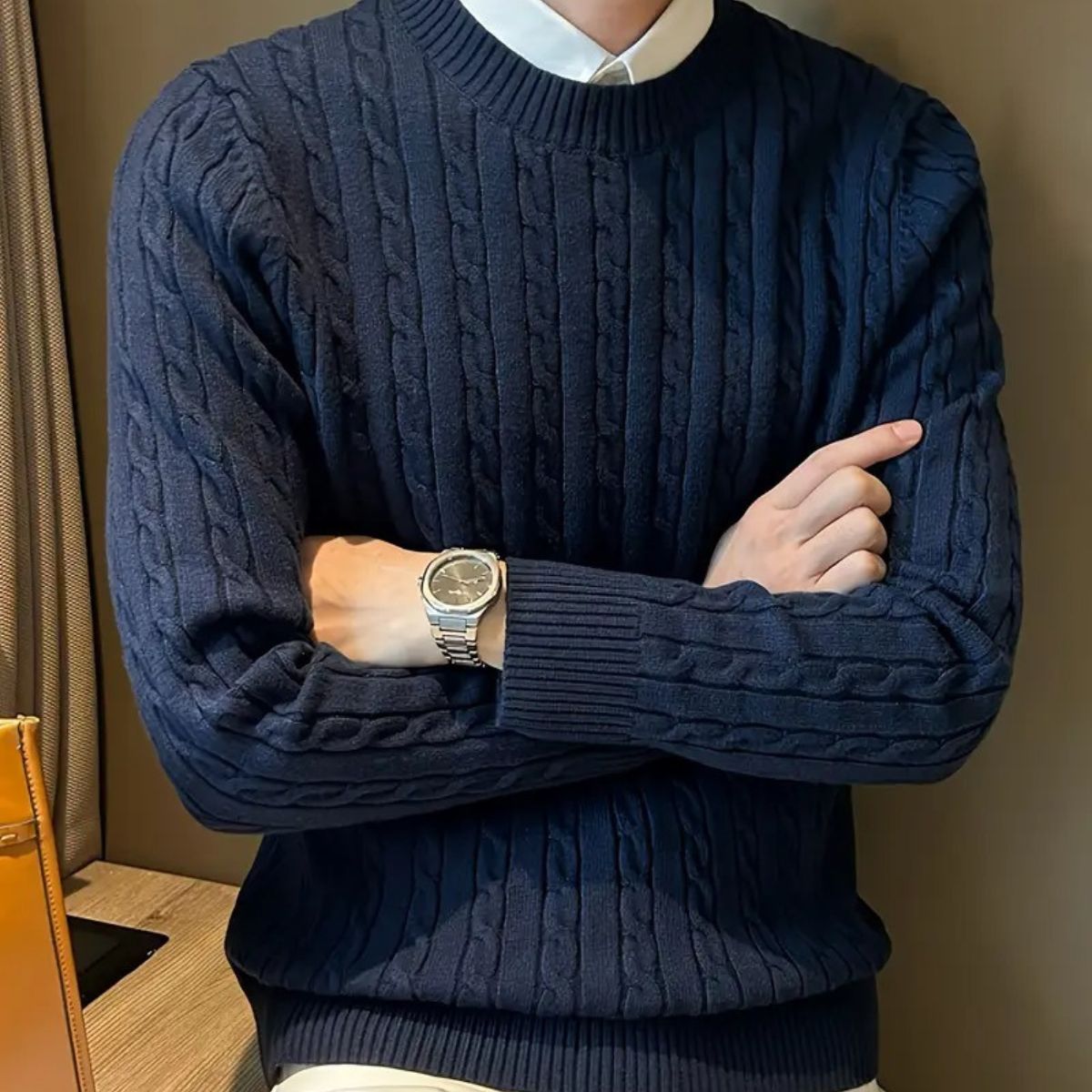 Navy cable-knit crewneck sweater with ribbed cuffs, shown worn