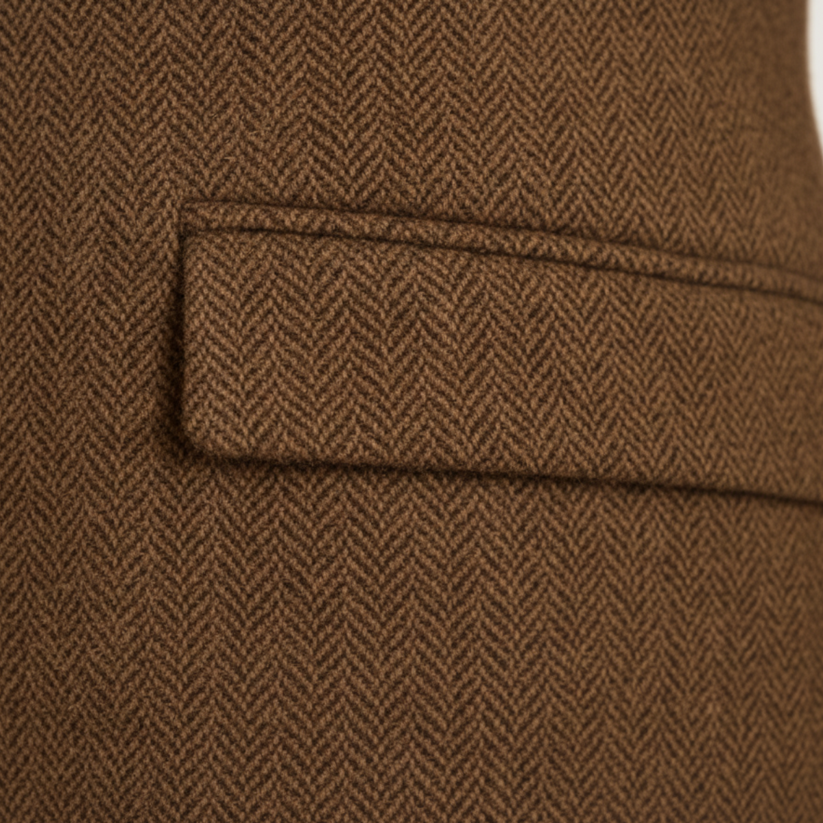 Brown tweed blazer flap pocket close-up with stitched border