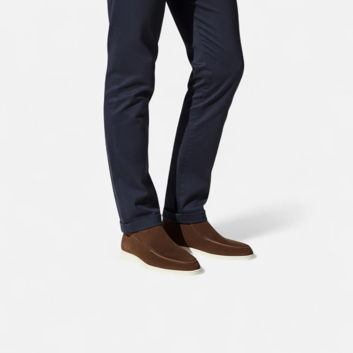 Brown suede slip-on loafers with moc-stitched trim and white rubber sole