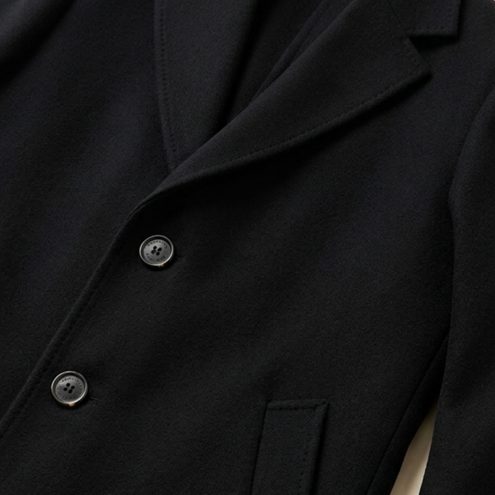 Black wool overcoat close-up: single-breasted button placket with round buttons
