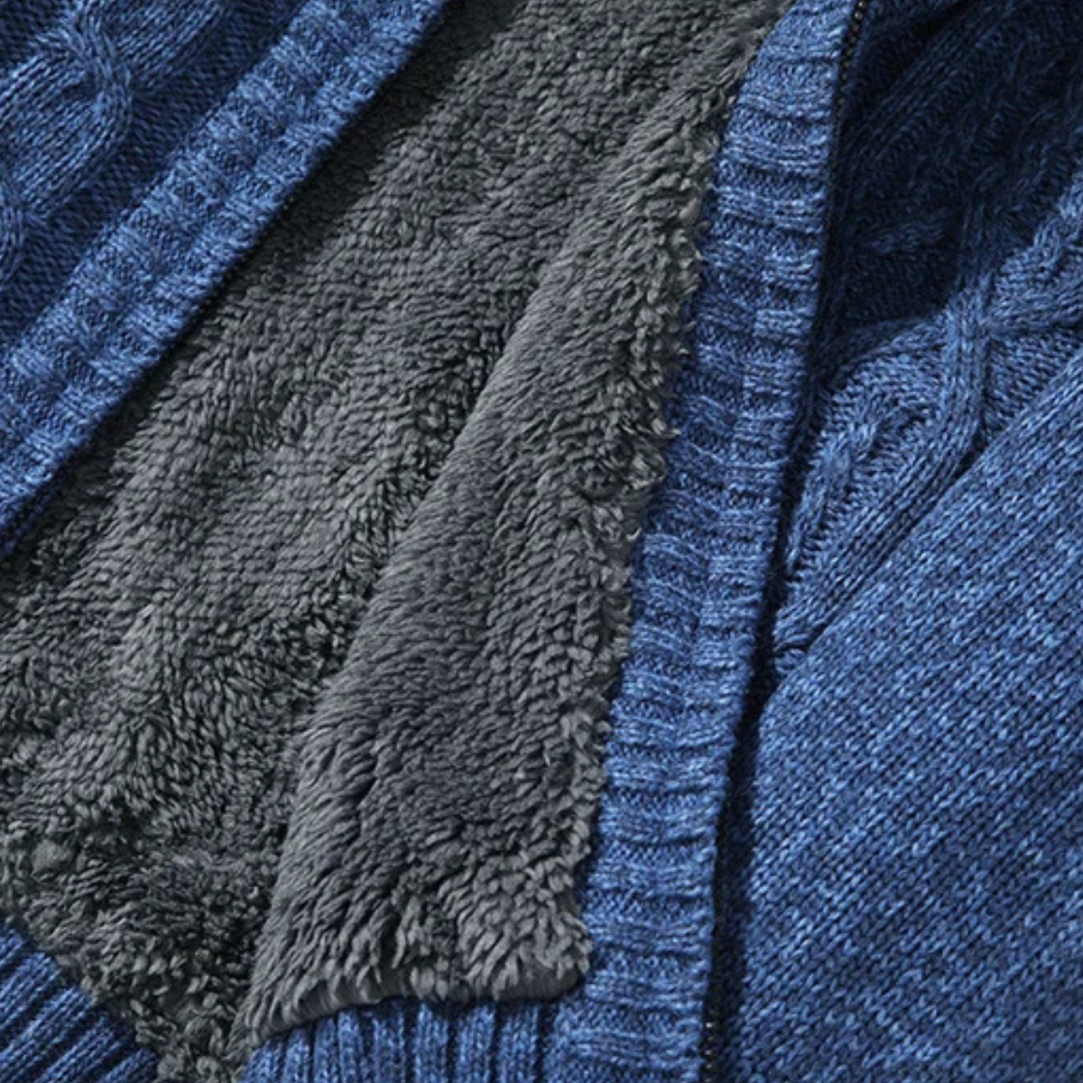 Close-up of blue knit cardigan with gray fleece lining and ribbed zipper edge