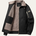 Black bomber jacket with tan shearling lining, stand collar, and zip front