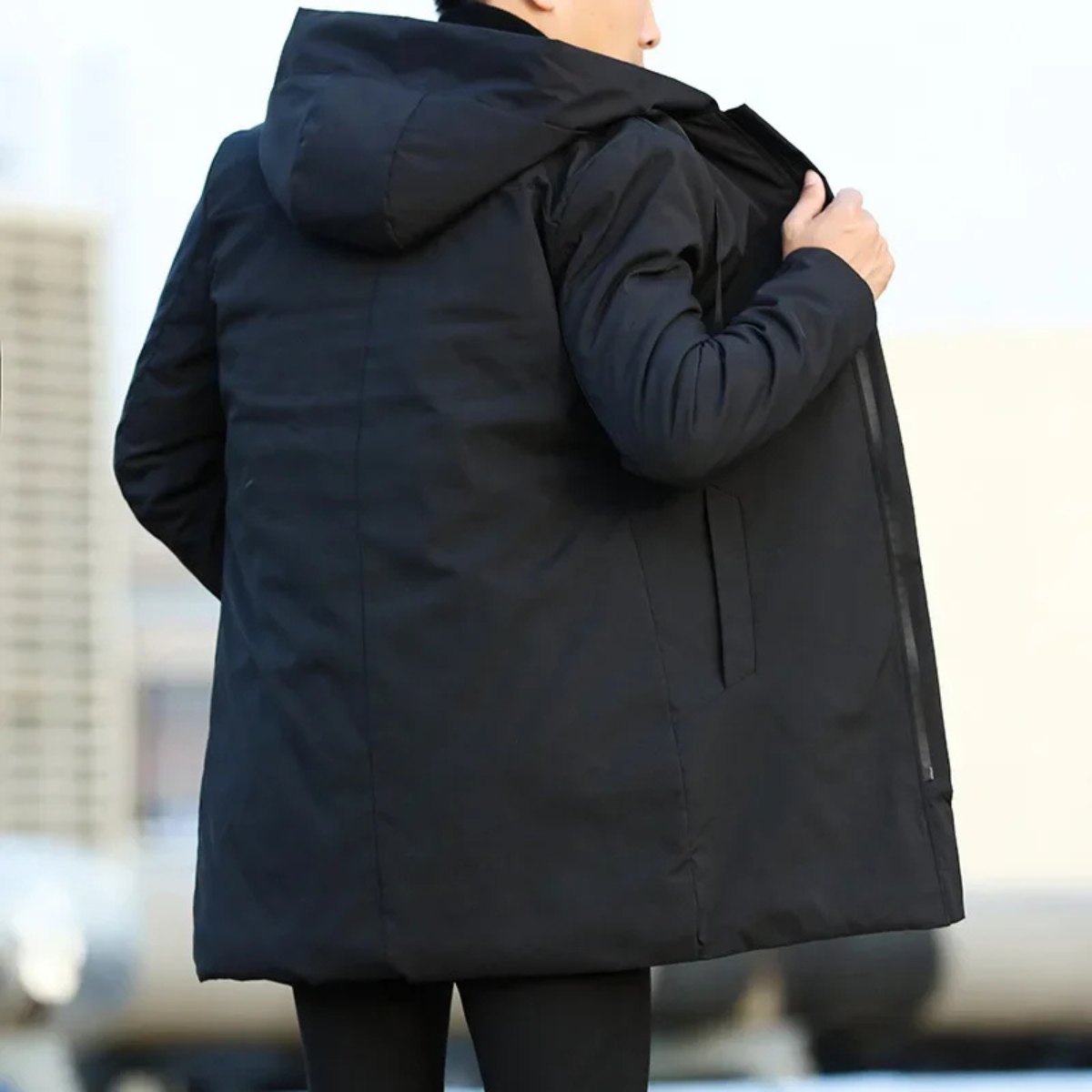 Men's long hooded rain jacket in dark color, back view with adjustable hood