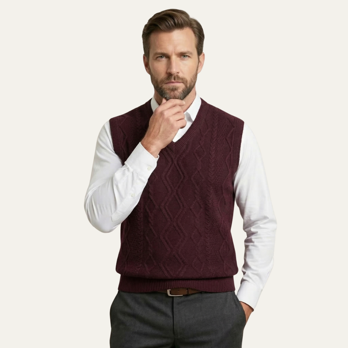 Men's burgundy v-neck cable knit sweater vest worn over a white button-down.
