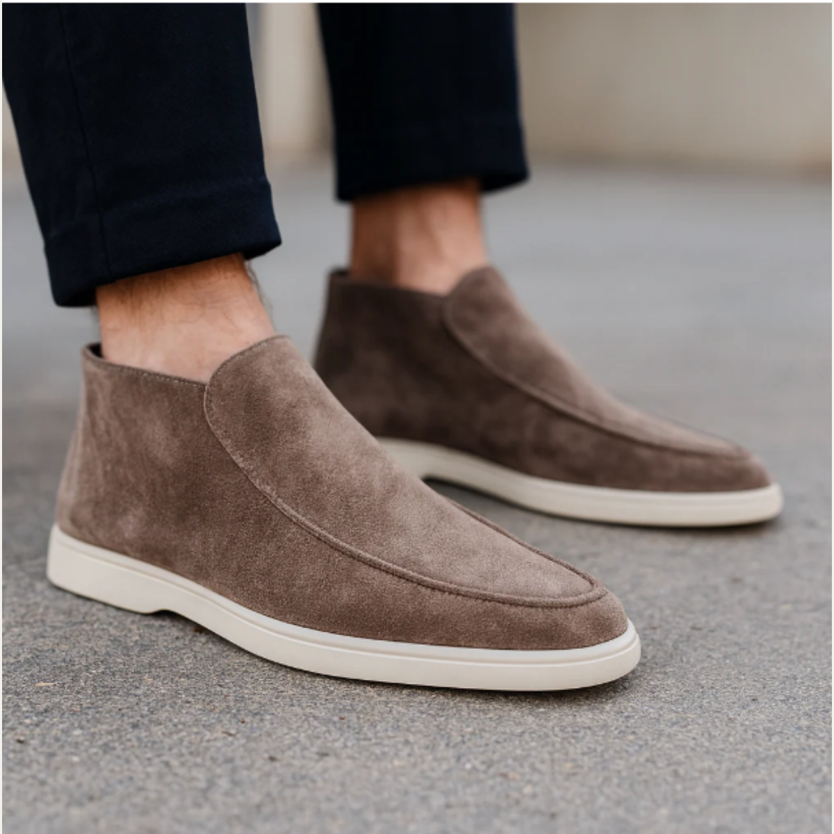 Men's taupe suede slip-on loafers with moc-stitch detailing and white rubber sole.