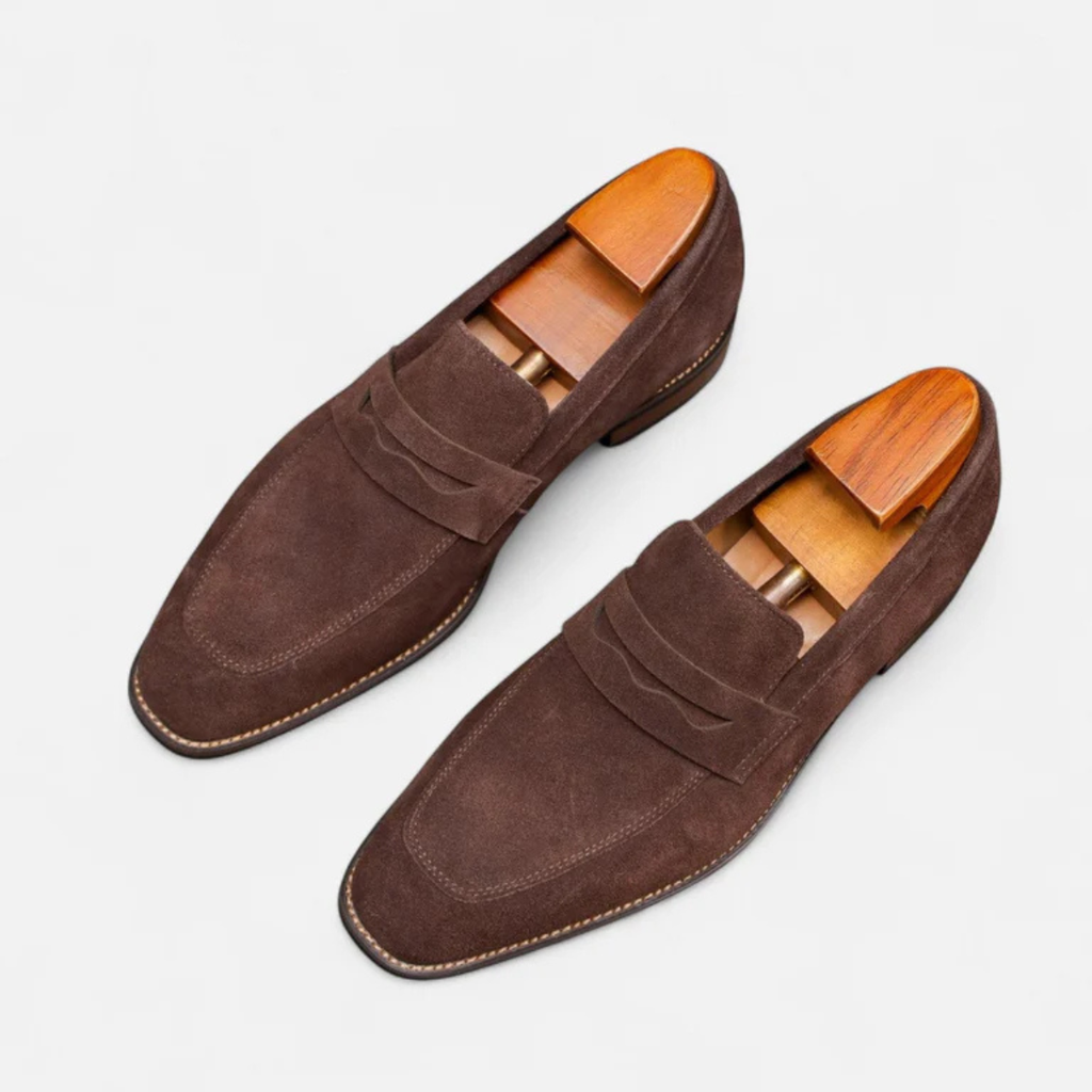 Men's brown suede penny loafers, slip-on design with side penny strap and tan lining.