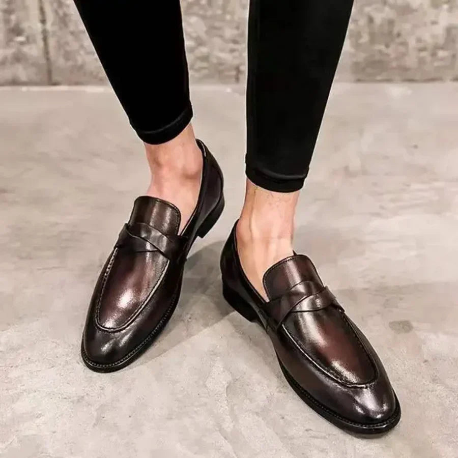 Brown leather penny loafers with penny strap and stitched apron toe