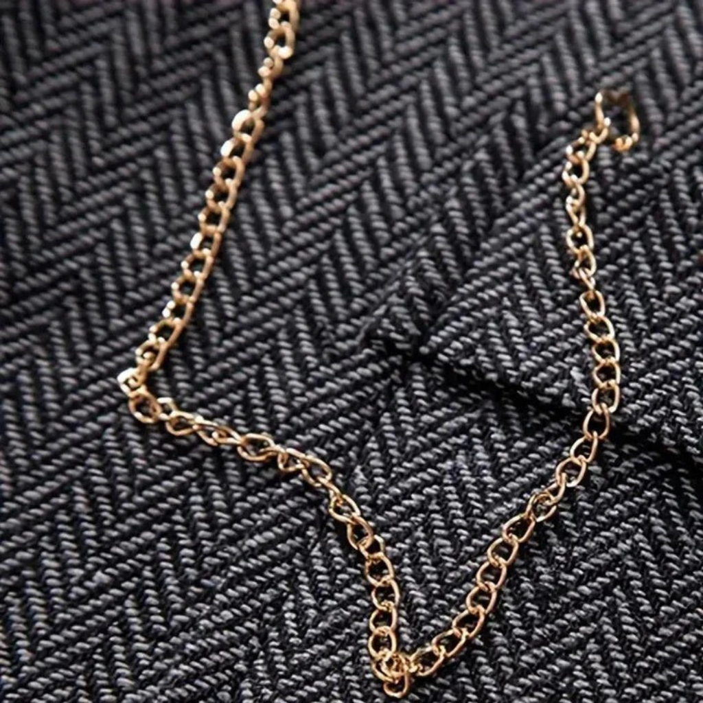 Men's tweed waistcoat gilet with gold-tone chain necklace over herringbone fabric
