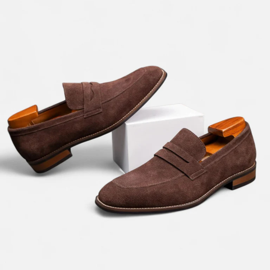 Men's brown suede slip-on penny loafers with side penny strap and stacked low heel.