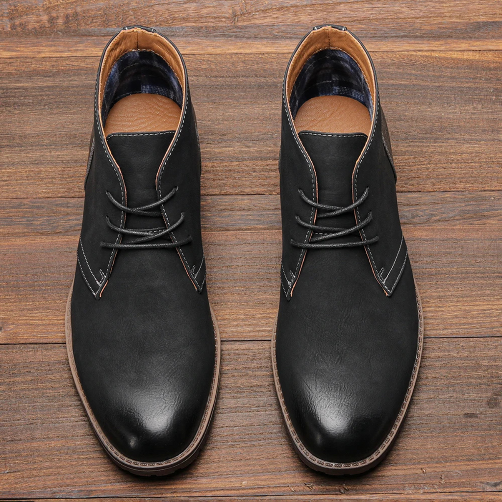 Black leather lace-up chukka boots with plaid lining and stitched toe cap