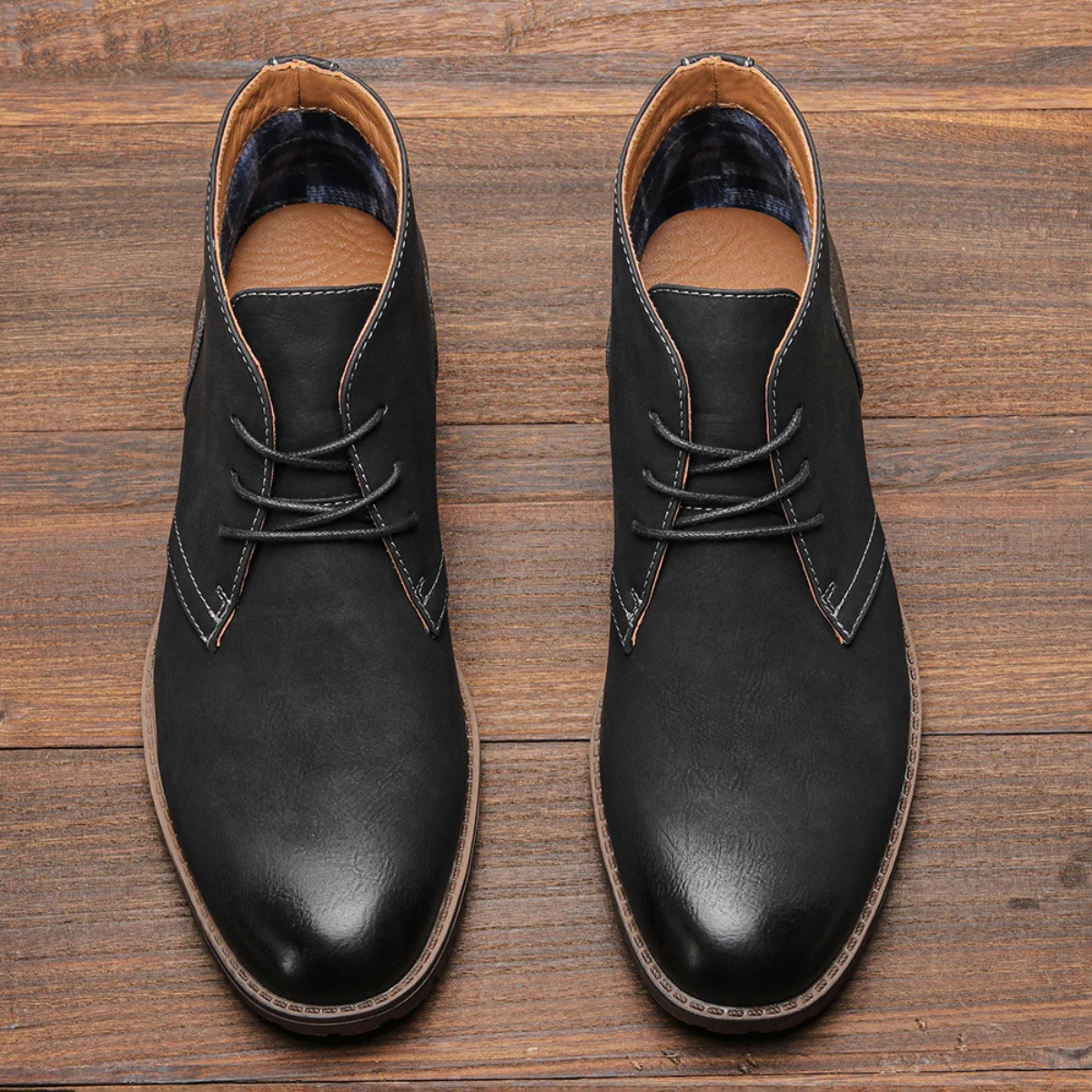 Black leather lace-up chukka boots with plaid lining and stitched toe cap