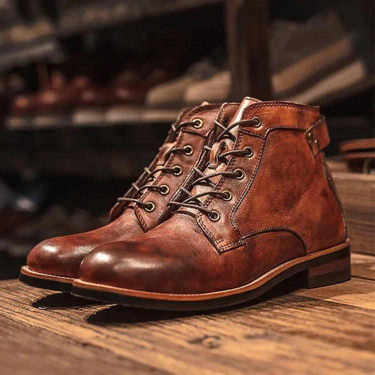 Men's brown lace-up ankle boots with round toe and low block heel on wooden floor