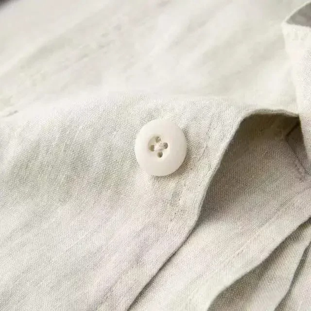 Cotton-linen blazer sleeve detail with white button and textured fabric