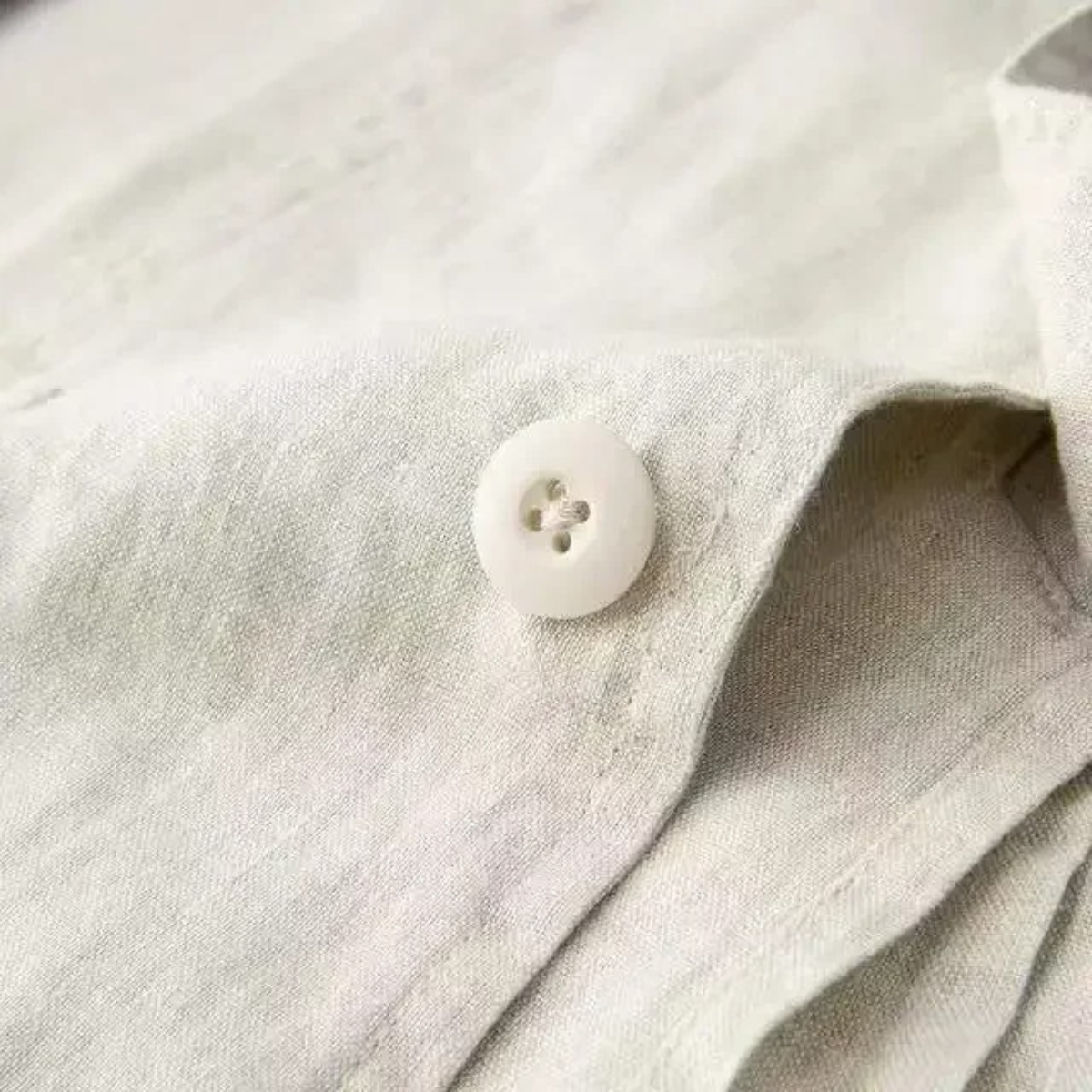 Cotton-linen blazer sleeve detail with white button and textured fabric