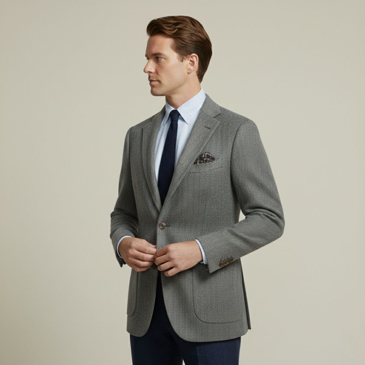 Gray men’s single-breasted blazer with notch lapels and flap pockets, worn