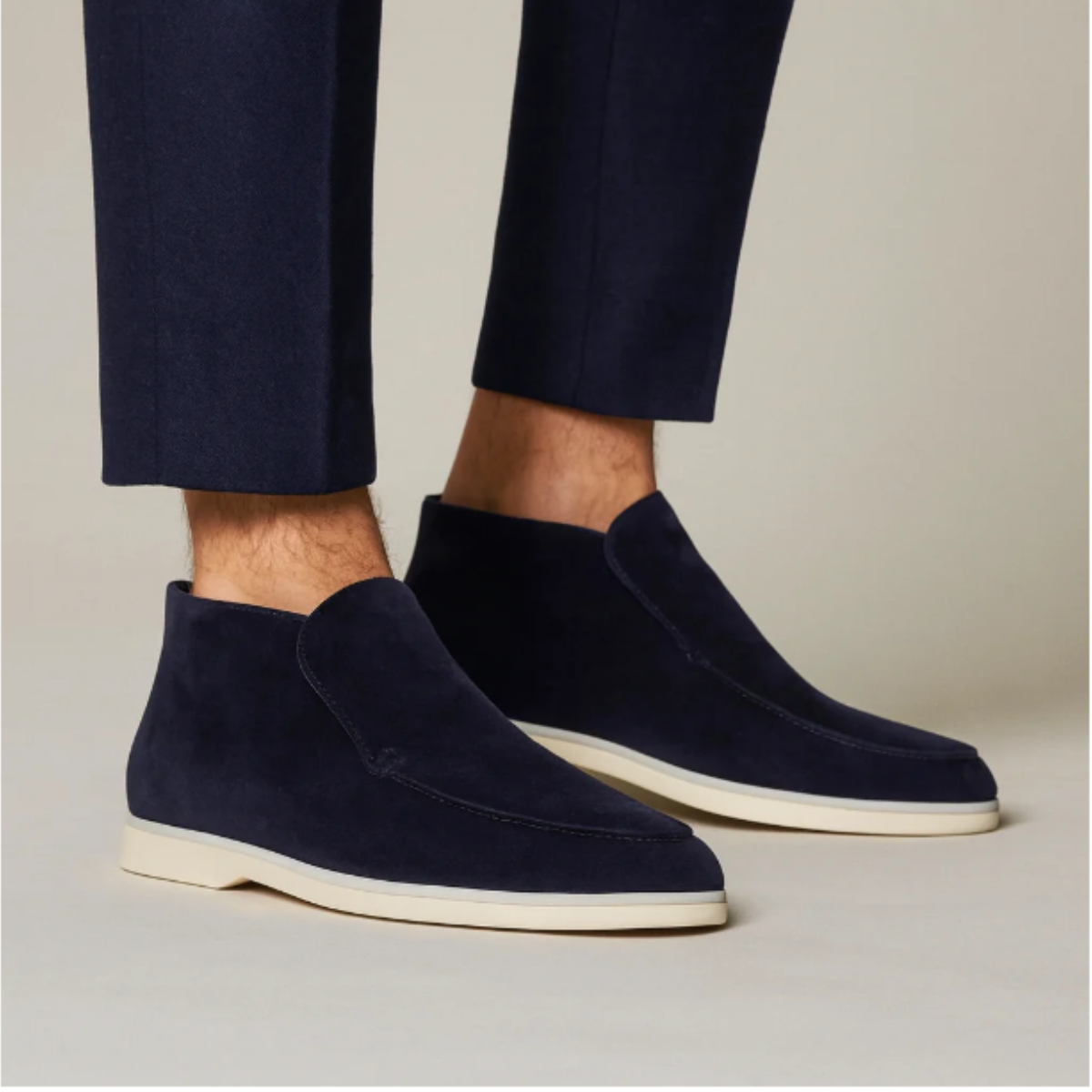 Men's navy suede slip-on loafers with moc-stitch seam and white rubber sole.