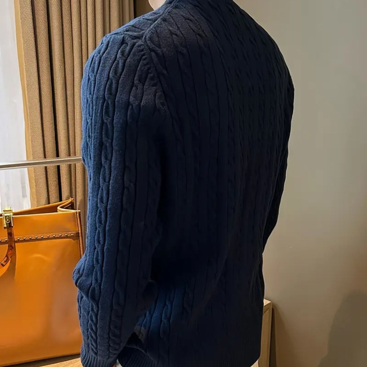 Navy cable-knit crewneck sweater, side view of textured knit sleeves